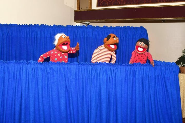 Three puppets performing in a show